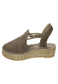 Bruine suède espadrille met een gesloten neus, open hiel, crisscross bandontwerp en een geweven juten zool. Platte, textuur rubberen buitenzool voor grip.