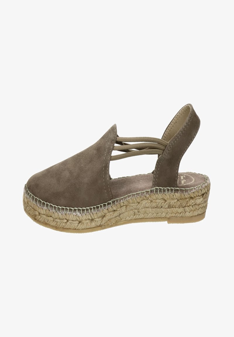 Bruine suède espadrille met een gesloten neus, open hiel, crisscross bandontwerp en een geweven juten zool. Platte, textuur rubberen buitenzool voor grip.