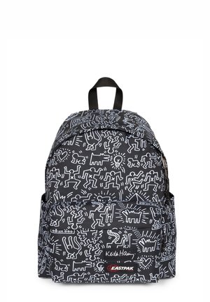 Sac à dos noir avec un motif blanc inspiré de Keith Haring, doté de bretelles réglables, d'une poignée supérieure et d'une poche avant zippée.