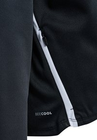 Top atletico nero realizzato in tessuto testurizzato, con un dettaglio della tasca con zip bianca e il logo "BEECOOL" sull'orlo.