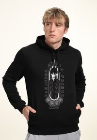 Hoodie nero in cotone, con una grafica di un personaggio e la scritta "DARKNESS...MY OLD FRIEND" con accenti floreali. Cappuccio regolabile con cordino.