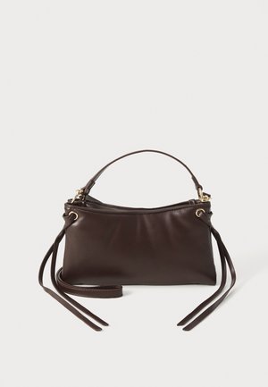 Tummanruskea nahkainen käsilaukku, jossa on yksittäinen yläkahva, kullanväriset metalliosat, vetoketjukiinnitys ja pitkät koristeelliset nahkahihnat kummallakin sivulla.