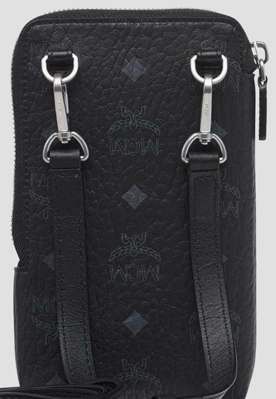 Zwarte crossbodytas van gebobbeld leer met zilverkleurige sluitingen en subtiel MCM-logo patroon, bovenaan afgesloten met een ritssluiting.