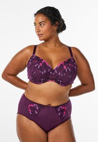 Vijolični komplet spodnjega perila z rožnatimi in vijoličnimi vezeninami. Modrček z oblikovanimi skodelicami in nastavljivimi naramnicami; ujemajoče se hlačke z visokim pasom.