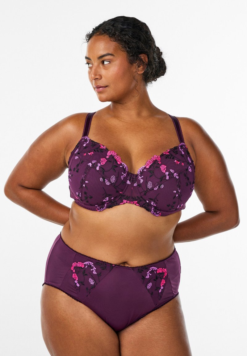 Vijolični komplet spodnjega perila z rožnatimi in vijoličnimi vezeninami. Modrček z oblikovanimi skodelicami in nastavljivimi naramnicami; ujemajoče se hlačke z visokim pasom.