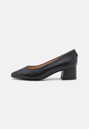 Black leather pump with a pointed toe, low block heel, smooth texture, and minimalistic design. No visible hardware or patterns.