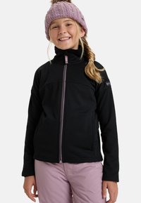 Černá fleecová bunda s vysokým límcem a růžovými zipovými detaily. Spárována se světle růžovými kalhotami a pletenou růžovou čepicí s bambulí.