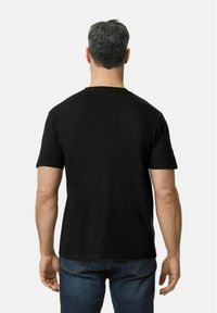 Svart kortermet t-skjorte med rund hals, laget av bomull, med en glatt tekstur og klassisk passform, brukt med blå jeans.