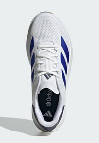 Baskets blanches de sport avec une tige en mesh, des rayures bleues et un col rembourré. Comprend une semelle intérieure Ortholite et une semelle texturée pour une meilleure adhérence.