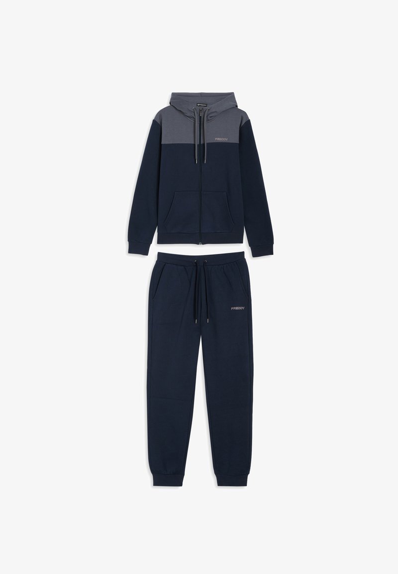 Sudadera con capucha azul marino con detalles grises y cremallera, combinada con pantalones deportivos a juego que tienen una cintura elástica y bolsillos laterales.