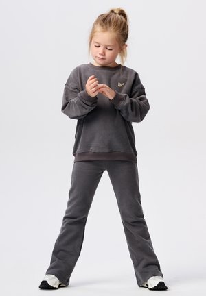 Grijze katoenen trui- en broekset; de trui heeft ribgebreide manchetten en een klein logo; de broek is uitlopend, heeft een gladde textuur en een casual pasvorm.