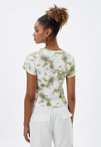 Korte mouwen, tie-dye t-shirt in wit en groen. Zacht, gestructureerd stof met een getailleerde pasvorm en ronde hals. Heeft een klassieke uitstraling.