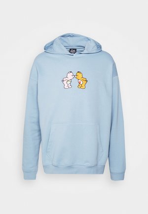 Lichtblauwe hoodie met voorzak met twee kleine Care Bears die elkaar aankijken en met hun neuzen in het midden van de borst aanraken.