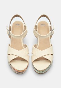 Beige nahk sandaalid, millel on ristuvad kangast rihmad, pahkluuse pandla ja mitmevärviline kudumine espadrille tallal. Sile sisetald.