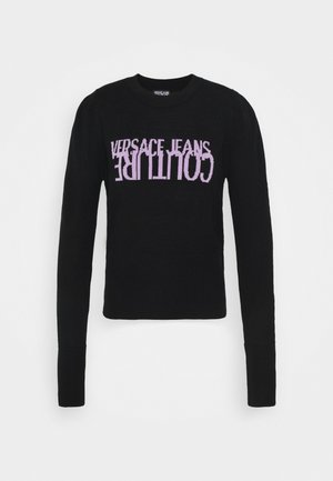Pull noir à manches longues avec le texte violet "VERSACE JEANS COUTURE" imprimé à l'envers sur la poitrine.