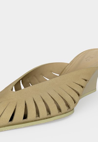 Μπεζ σουέτ πλατφόρμα πέδιλο με ανοιχτά δάχτυλα, κάθετες λωρίδες με κοψίματα και χαμηλό κεκλιμένο τακούνι.