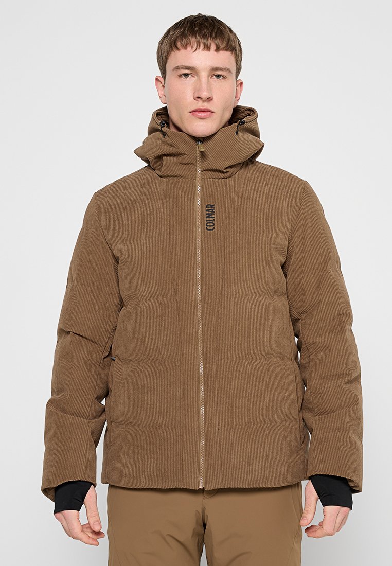 Braune Kord-Jacke mit Steppung, hohem Kragen, Frontreißverschluss und doppeltem Kordelzug an der Kapuze. Hat ein Logo auf der oberen linken Seite.