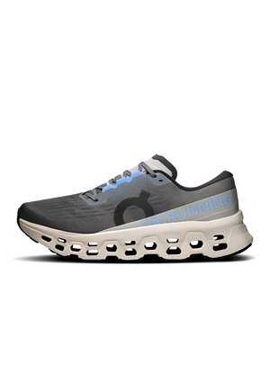 Scarpa da corsa grigia e nera con suola beige caratterizzata da grandi fori di ventilazione e scritta "ON RUNNING" sul lato.