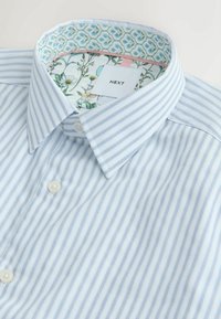 Svetlomodrá a bielo pruhovaná košeľa na gombíky s kvetinovým vzorom na vnútornom golieri a štítkom "NEXT".