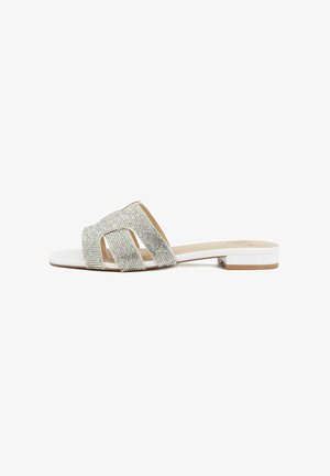 Sandalo bianco piatto con tre larghe fasce decorate con strass e tacco basso a blocco su sfondo bianco semplice.