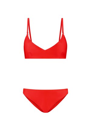 Sarkans peldkostīms, kas sastāv no v veida braleta topa ar regulējamām siksnām un zemas augstuma apakšdaļas, abi izgatavoti no gludas auduma.