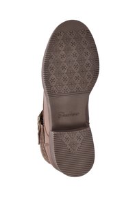 Bruine Skechers laarzenzool met een bloemenpatroon in de loop en gestreepte gripvlakken, gefotografeerd van onderen.