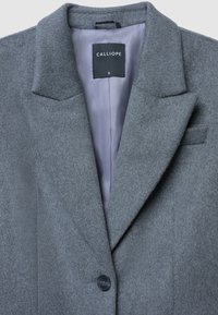 Blazer grigio in misto lana con collarino a lobo, chiusura a un bottone e fodera grigia liscia. Etichetta con la scritta "CALLIOPE" taglia piccola.