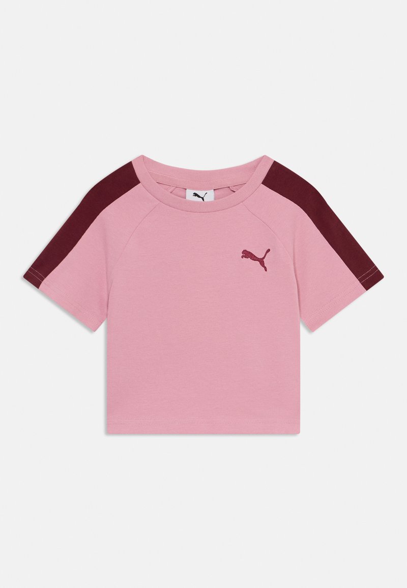 Roza kratka majica s kratkimi rokavi z maroon raglan rokavi, izdelana iz mehkega blaga. Ima majhen vezen logotip na prsih.