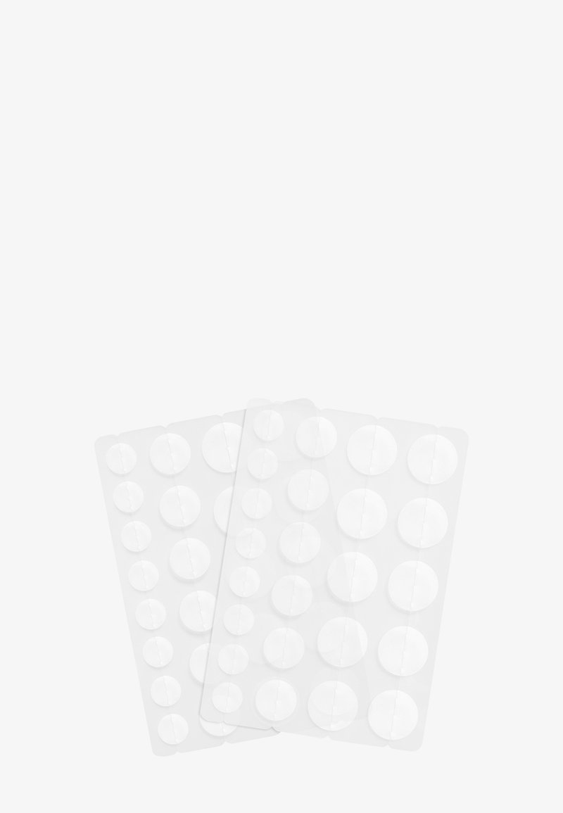 Deux plaquettes thermoformées contenant des comprimés ronds blancs de tailles variées sur un fond blanc.