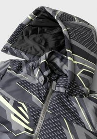 Giacca grigia con motivi geometrici in nero e accenti in giallo neon. Presenta un cappuccio, chiusura con zip e un tessuto liscio e strutturato.