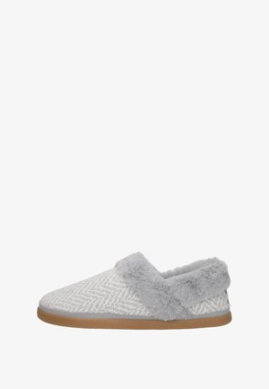 Zapatilla de casa gris tipo slip-on con forro y ribete de suave piel sintética, parte superior de tela texturizada y suela de goma marrón.