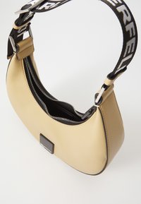 Beige leather handbag with a curved shape, featuring a black zipper and a black strap with "PERFECT" text. Includes a small black logo detail.