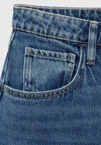 Donkerblauwe denim jeans met een zichtbaar voorvak en gestikte naden. De textuur is glad met een lichte vervaging.