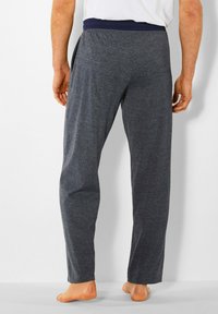 Grijze sweatpants met een marineblauwe elastische tailleband, middelzware stof, rechte benen en zonder zichtbare patronen of accentueringen.