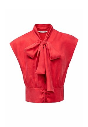 Blouse rouge sans manches avec large col et grand nœud noué au cou, boutonnée à l'avant et taille ajustée.