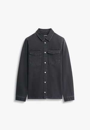 Crna traper košulja s ovratnikom, dva džepa na prsima, dekorativno šivanje na džepovima i bijelim dugmadima. Mekana tekstura.