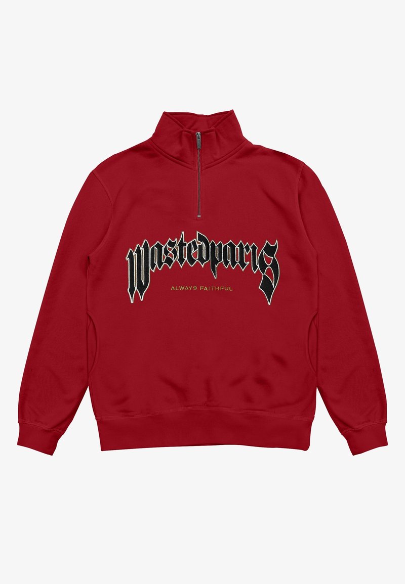 Sweat-shirt rouge avec col à demi-fermeture éclair, arborant un logo noir "Wastedparis" et un texte vert "ALWAYS FAITHFUL" imprimés sur le devant.