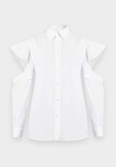 Cămașă albă cu nasturi, cu detalii decupate pe umeri și mâneci lungi, având un guler clasic și mansete.