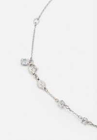Silver chain necklace featuring various clear geometric charms, including a clasp and decorative accents, with a sleek finish and intricate links.