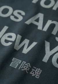 Tela oscura con texto en colores claros y audaces que incluye palabras y caracteres. El texto incluye frases en inglés y un carácter chino.