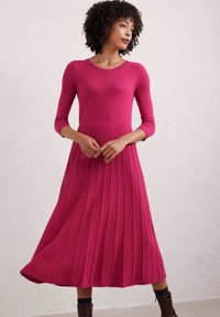 Abito lavorato a maglia fucsia con maniche lunghe, texture a costine e gonna plissettata, caratterizzato da un corpino aderente e scollatura rotonda.
