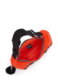 Orange nylonväska med svart rem, silverdragkedja och mjuk svart pom-pom-detalj; har ett rymligt fack klätt i matchande orange tyg.