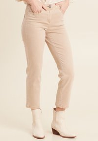 Beige denim jeans met een slim fit, normale taillehoogte en cropped lengte. Voorzien van een traditionele vijf-pocket ontwerp en een sluiting met bovenste knoop.