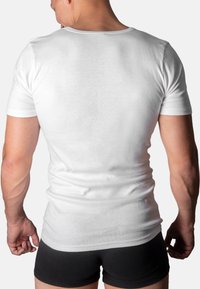 White cotton T-shirt with short sleeves, fitted design, smooth texture, and rounded neckline, viewed from the back on a male model.