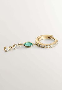 Aro de oro con un piedra verde en corte marquise y tres piedras transparentes. Los detalles texturizados en la banda cerca de las piedras realzan el interés visual.