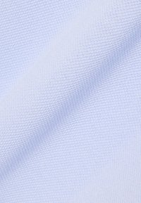 Tissu bleu clair texturé avec un motif tissé lisse. Le matériau semble doux et souple, adapté pour des vêtements ou des applications de rembourrage.