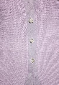 Cardigan a maglia di un leggero viola, caratterizzato da cinque bottoni decorativi con accenti in perle e cristalli, tessuto testurizzato e un design leggermente aderente.