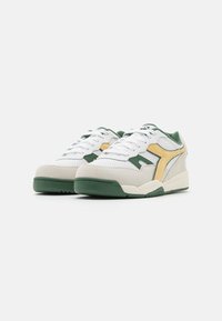 Sneaker bianche con dettagli verde, in pelle scamosciata e cuoio, punta perforata, logo giallo laterale, lacci piatti e suola imbottita.