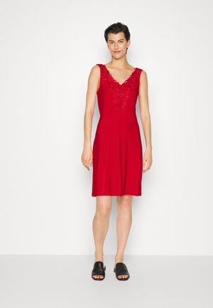 Vestido vermelho sem mangas com decote em renda floral, tecido suave, altura acima do joelho, combinado com sandálias pretas de deslizar.