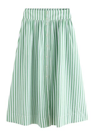 Taille d'une jupe blanche et verte à rayures verticales avec quatre boutons blancs au centre, portée avec un top blanc en côte.